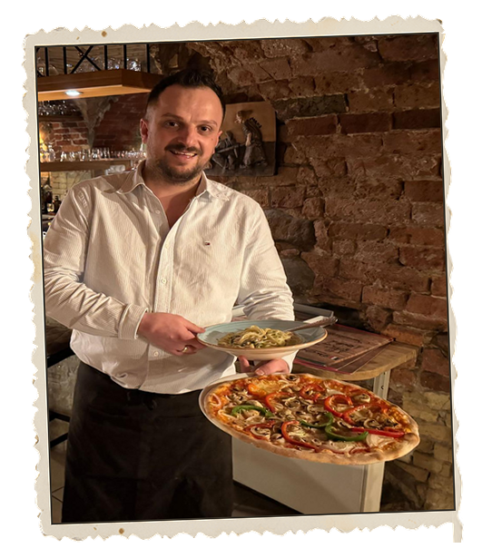 Inhaber Gianni serviert frische Steinofenpizza und Pasta im Ristorante Da Gianni
